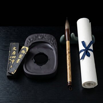 Traditional Chinese Scholar's Four Treasures: A neat arrangement of an inkstone, an inkstick with gold leaf characters, a calligraphy brush with a bamboo handle, and a roll of white Xuan paper,