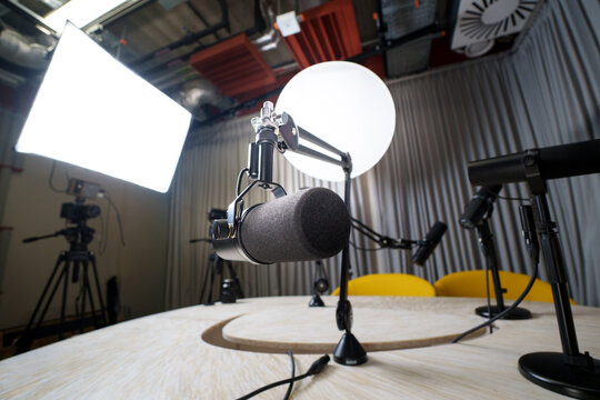 Videocast recording studio professional microphones cameras softbox lighting equipment broadcast desk yellow chairs