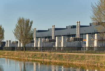 Data center infrastructure and cloud computing technology modern server farm building in Middenmeer Netherlands cooling towers security fence © VeugerStock