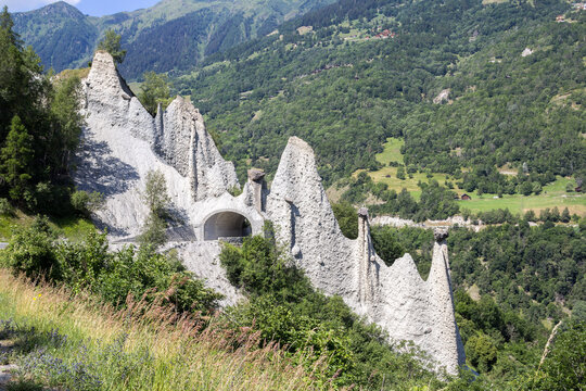 Pyramides d'Euseigne or fairy chimney rock formations in Swiss Alp. Rocks stay in balance on eroded former glacier moraine. A road pass was built under geological formation.