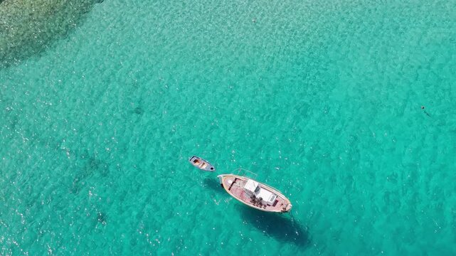 Traditional wooden fishing boat moored in turquoise water, kayaking in Limeni village on Mani peninsula, Peloponnese, Aerial view