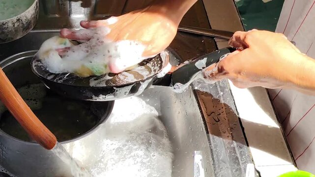 Woman wash the frying pan