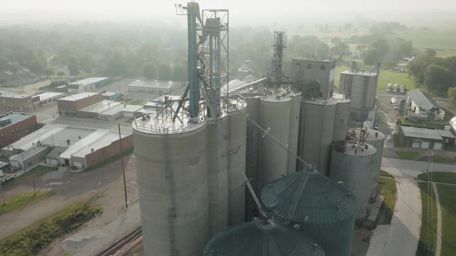 Aerial orbit of a bin next to a railroad in rural iowa.