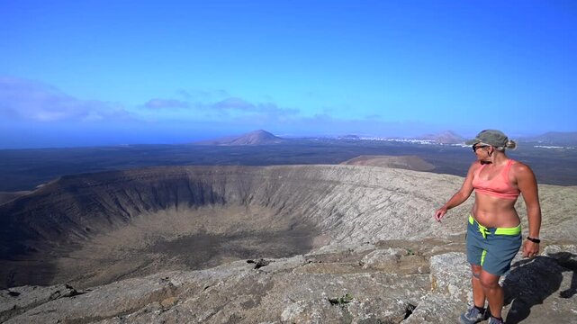 Female Hiker ascending the Volcanic Switchback Trail Toward the Crater Rim of Caldera Blanca in Lanzarote