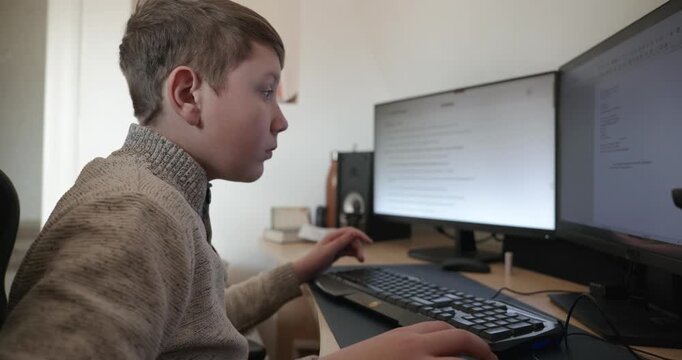 Kid Boy Use Desktop Computer for Study Typing and Reading. 4K 10-bit