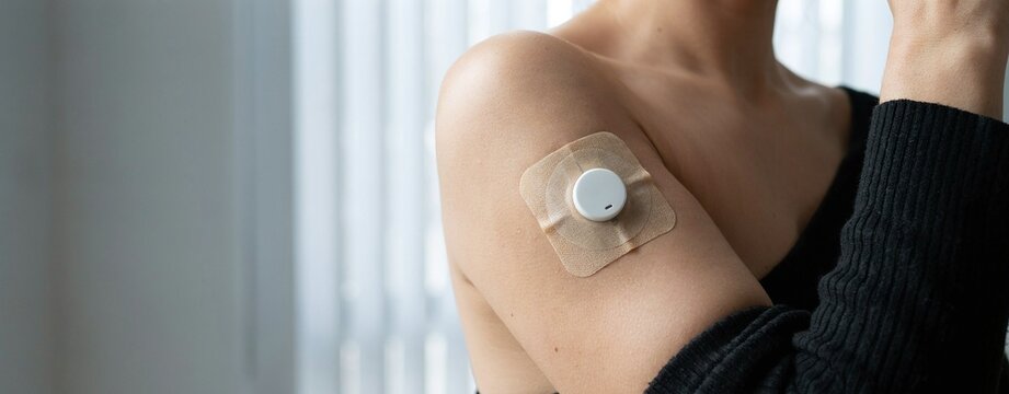 diabetes sensor patch worn on a woman's arm for daily blood sugar measurement and health care.