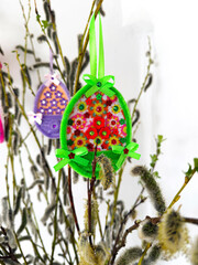 Spring floral arrangement with decorated felt eggs on blooming willow twigs, festive home interior decor. © Ирина Старикова