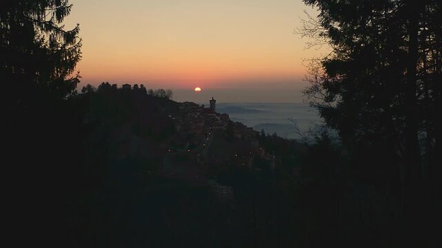 Sacro Monte di Varese sunrise, Santa Maria del Monte silhouette, misty valley, warm orange dawn light, panoramic Italy landscape, no people, copy space, cinematic tripod zoom in. UNESCO site