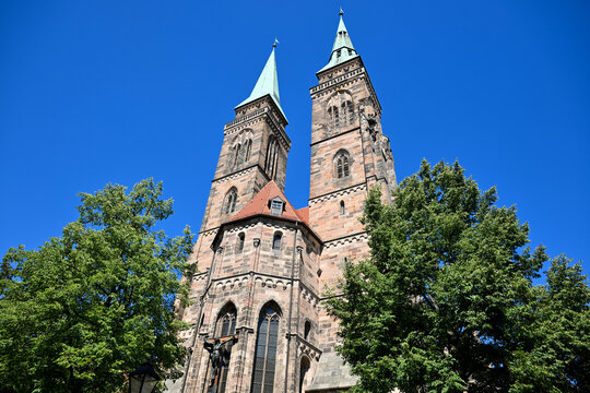 Historic stone church towers with copper spires and blue sky