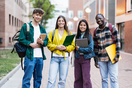 Positive students standing on university campus, ready to start academic course lectures