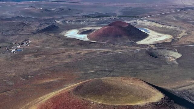 A smooth, medium-altitude aerial sequence tracking over the distinct volcanic maar craters and central cone landscape of Meke Lake.