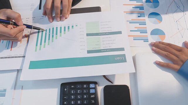 Close up of businesswomen or accountant using calculator calculate while working analytic business report on the workplace, Planning financial and accounting concept.