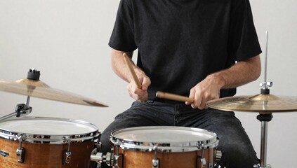 Fototapeta premium Torso shot of a drummer performing on a drum set with drumsticks in a studio setting