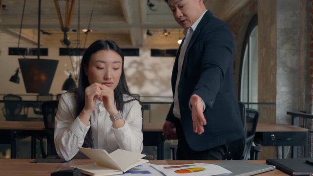 Stressed Asian business woman Korean girl intern businesswoman feeling mental tension angry furious Chinese Japanese boss man businessman yelling throwing documents incorrect data two colleagues team
