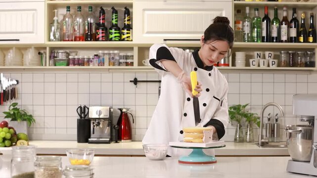 Skilled pastry chef spread frosting, smooths sweet cream icing with spatula for birthday bakery order in modern kitchen, cake spins slowly on turntable, ideal baking, confectionery, culinary concepts