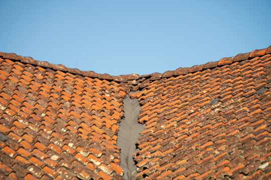 Traditional terracotta or orange-colored clay tiles are commonly found on older buildings. A traditional roof against a blue sky.