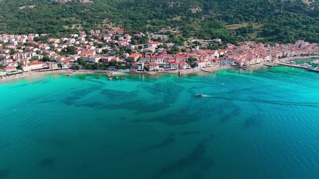 	
Wide drone panorama of Ba&scaron;ka Bay featuring historic town, marina, long pebble beach, turquoise Adriatic Sea and impressive rocky mountain landscape