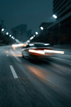 Motion blurred sports car speeding on city highway at night for background and banner design