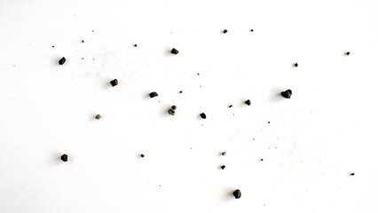 Obraz premium Scattered black coffee beans isolated on clean white background with scattered