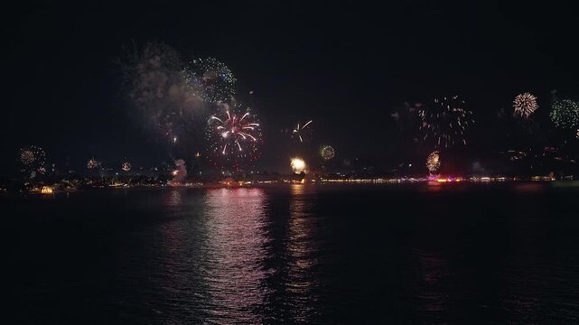 Colorful New Year Fireworks Illuminating a Tropical Island Coast Above Calm Sea Water at Night, Festive Holiday Celebration, Bright Reflections and Winter Vacation