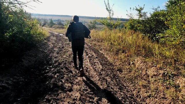 Volunteers in protective uniform jogging on dirty country road at frontline city in Ukraine. Rescue workers running to help animals and people from areas shelled by russian army. Slow motion