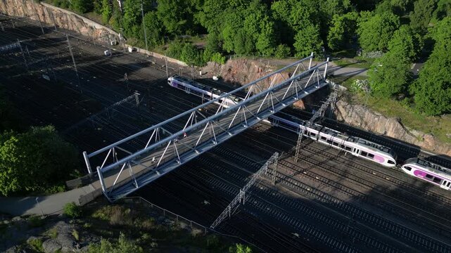 Aerial drone view of Linnunlaulu Bridge by T&ouml;&ouml;l&ouml;nlahti in Helsinki, Finland, crossing over the railway tracks.