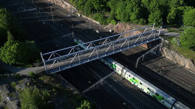 Aerial drone view of Linnunlaulu Bridge by T&ouml;&ouml;l&ouml;nlahti in Helsinki, Finland, crossing over the railway tracks.
