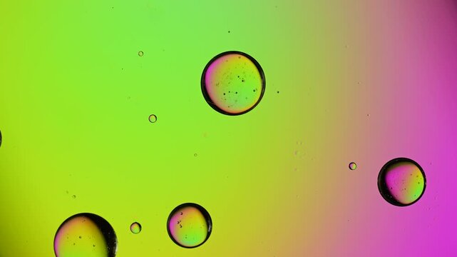 Psychedelic colorful oil bubbles floating on water surface