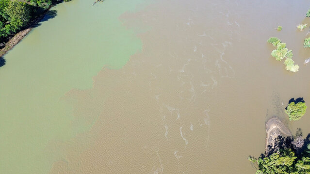 Aerial view of the confluence of the Vaal river and the Orange river south of the town of Douglas, Northern Cape, where brown and green river water merge