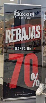 Vista de cerca de cartel con texto Rebajas hasta 70% en escaparate de tienda de ropa de deportes Boxeur des Rues en Madrid, Espa&ntilde;a, 9 de julio de 2026