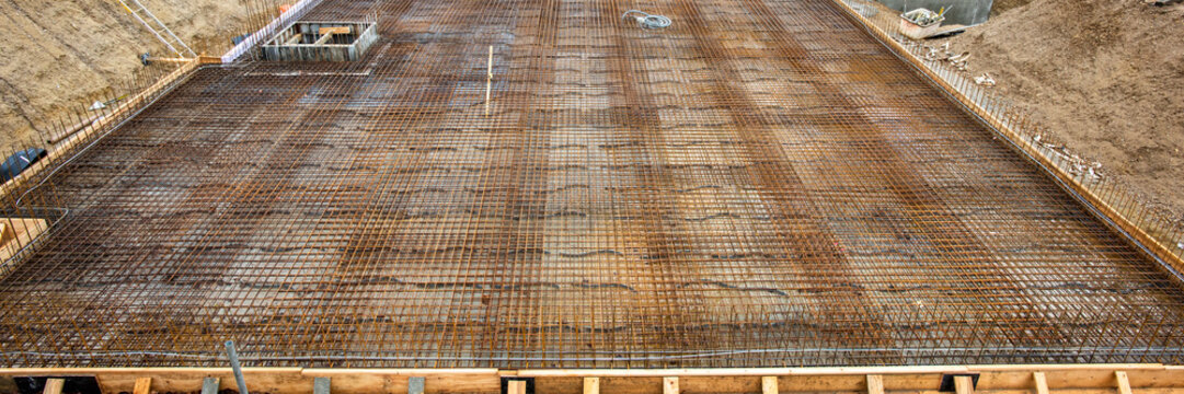 Im Fundament eines neuen Hauses werden Baustahlmatten als Bewehrung eingebracht