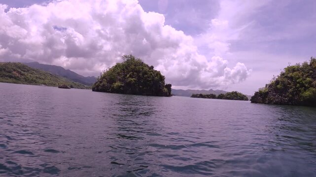 slow motion of horizontal pane view look out to shallow blue green turquoise peaceful lagoon from a small boat to mountains and coral rocks at small fishing village of Siete Pecados Marine Park Coron 