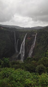 Wide view of Jog Falls showcasing cascading water and scenic natural landscape during rain