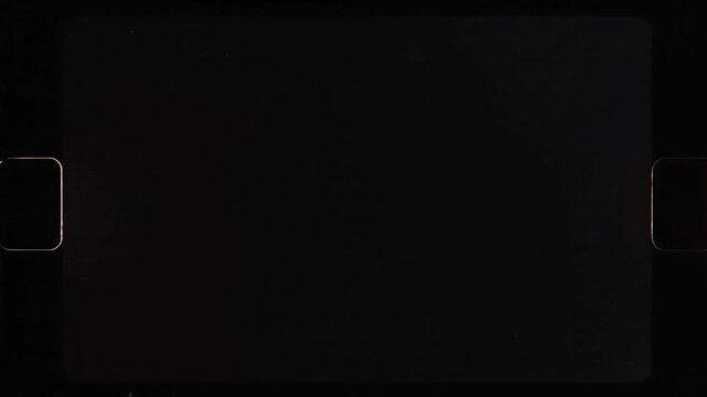 Vintage film frame with sprocket holes on black background for cinematic transition overlay