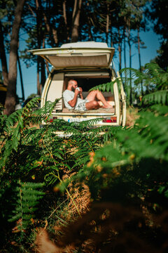 Man Relaxing in Open Vintage Campervan in Pine Forest &ndash; Van Life Lifestyle