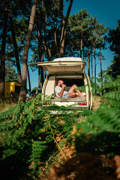 Man Relaxing in Open Vintage Campervan in Pine Forest &ndash; Van Life Lifestyle