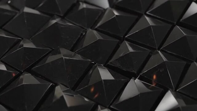A close up view of a repeating pattern of dark glossy pyramid shapes