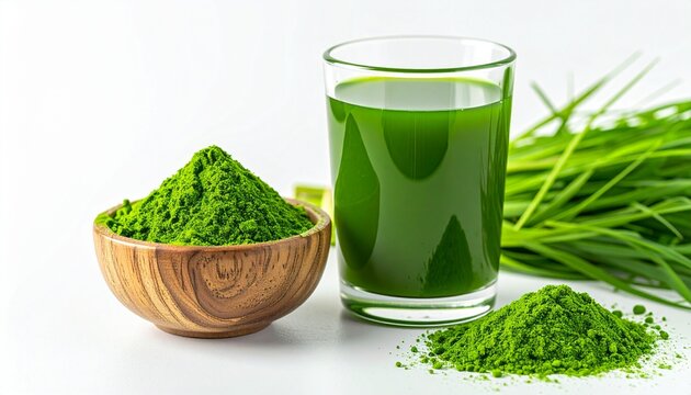 Glass of Green Barley Grass Juice with Wooden Bowl of Powder and Fresh Young Leaves on White Background