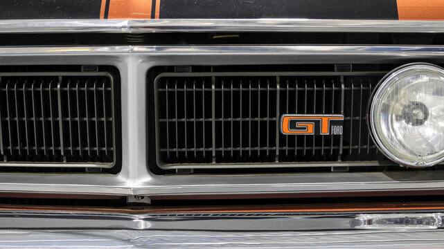 Perth, Western Australia, Australia - May 3 2026: Classic 1971 Ford Falcon XY GT muscle car front radiator grille. Orange  emblem badge, round headlight. Rare Australian high performance heritage