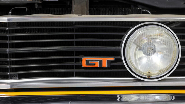 Perth, Western Australia, Australia - May 3 2026: Classic 1973 Ford Falcon XA 351 GT muscle car front grille. Orange emblem badge, round headlight. Rare australian performance classic automobile
