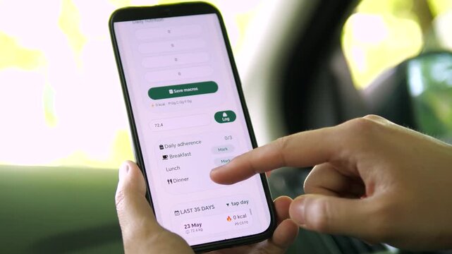 Celebrating 93 percent weight loss goal achieved. Person logs daily nutrition and macros via smartphone app in a car. High-quality visual of habit tracking and digital self-care. Ideal for lifestyle
