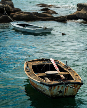 Two Rustic Wooden Fishing Boats Moored on Rocks by Calm Atlantic Sea