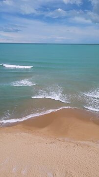 Aerial View of Waves Crashing on Sandy Beach and Open Sea