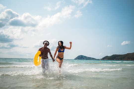Interracial couple enjoying a romantic beach getaway, embracing love, laughter, and togetherness
