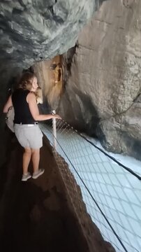 Caucasian woman hiking through the narrow rocky pathway of Partnach Gorge in Germany
