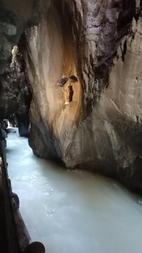 Fast flowing mountain river rushing through the deep rocky cavern of Partnach Gorge