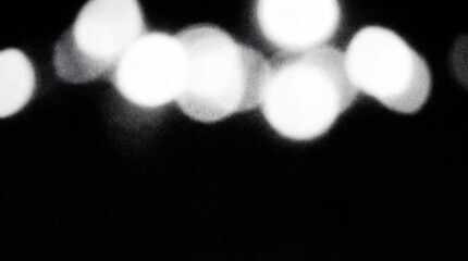 Fototapeta premium Abstract bokeh lights on black background, blurred glowing circles, monochrome defocused night light texture backdrop
