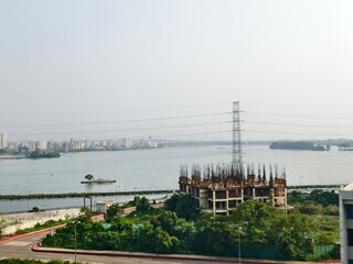 Naklejka premium Industrial Construction Site by Coastal Waterfront with Cranes and Urban Skyline