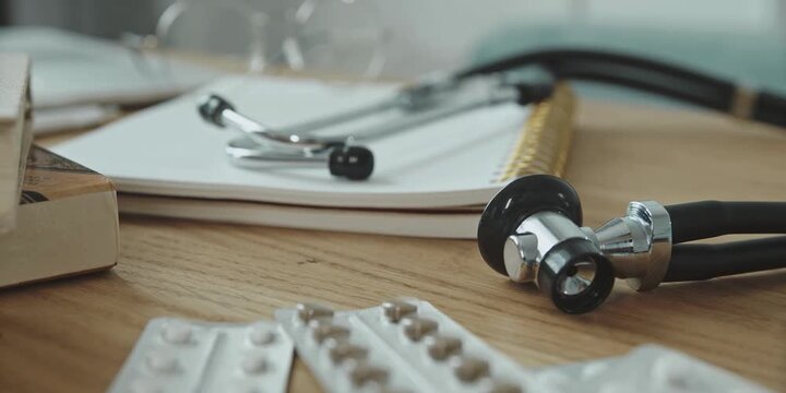 Medical professionals prepare for patient consultations with essential diagnostic equipment and pharmaceutical supplies thoughtfully arranged on a textured wooden desk surface