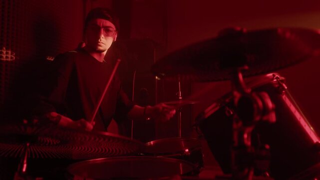 Caucasian young man playing drums in soundproof recording studio. Footage for music academy commercials, band promotions, or musical instrument marketing campaigns